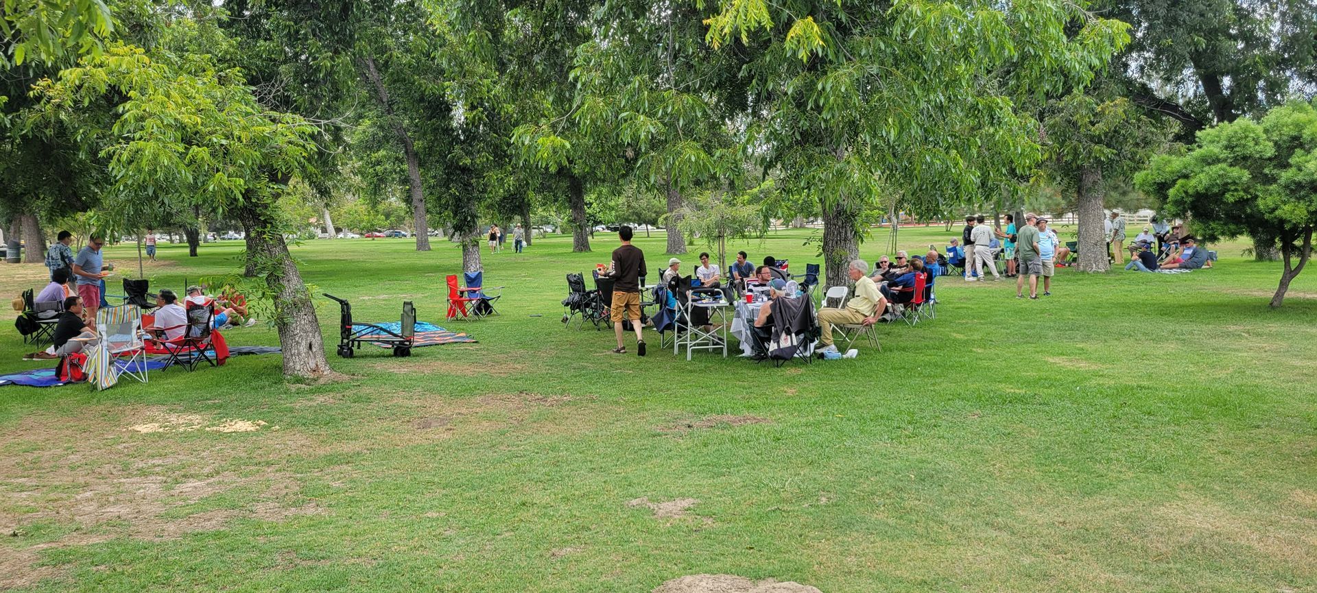Members relaxing on picnic chairs under shady trees at the Bette Davis Picnic Area, 2026